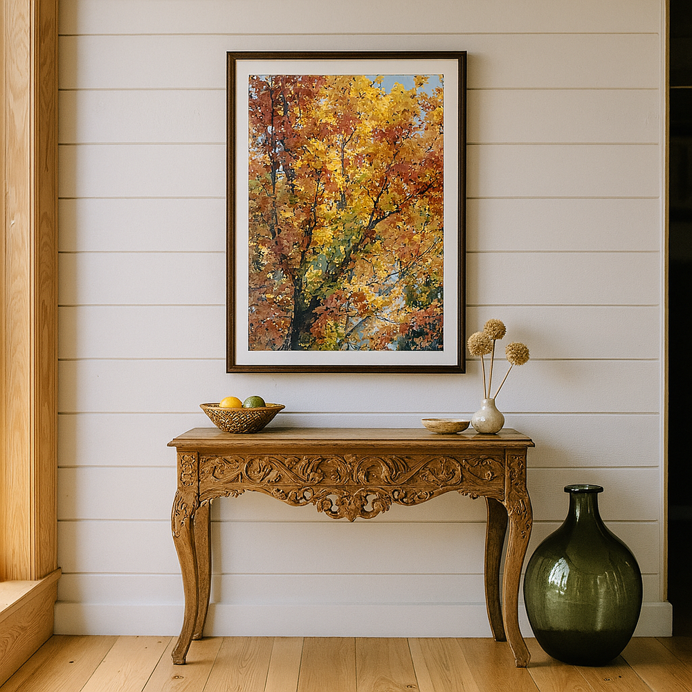 Decorative console table with a vase and bowl against a wall with a framed autumn tree painting.