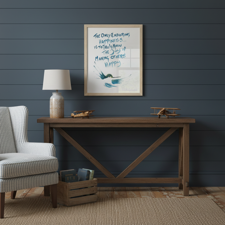 Boy's room room with wooden table, striped armchair, and framed artwork of a hummingbird on a dark blue wall - by Andrew Semple on Bromont Media