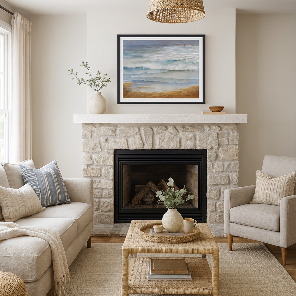 Living room with stone fireplace, beige sofa, armchair, and painting of ocean waves.