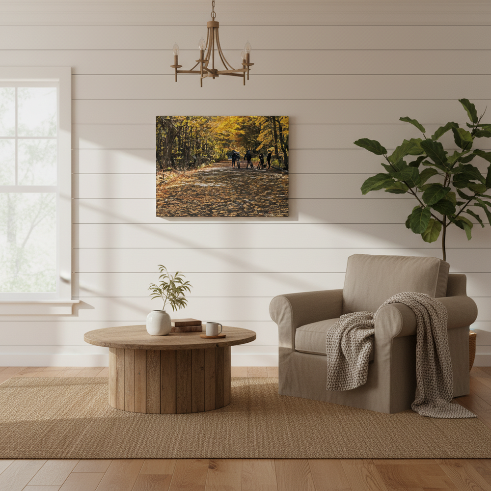 Living room with a beige armchair, wooden coffee table, and wall art of a forest scene - by Studio Shefford on Bromont Media