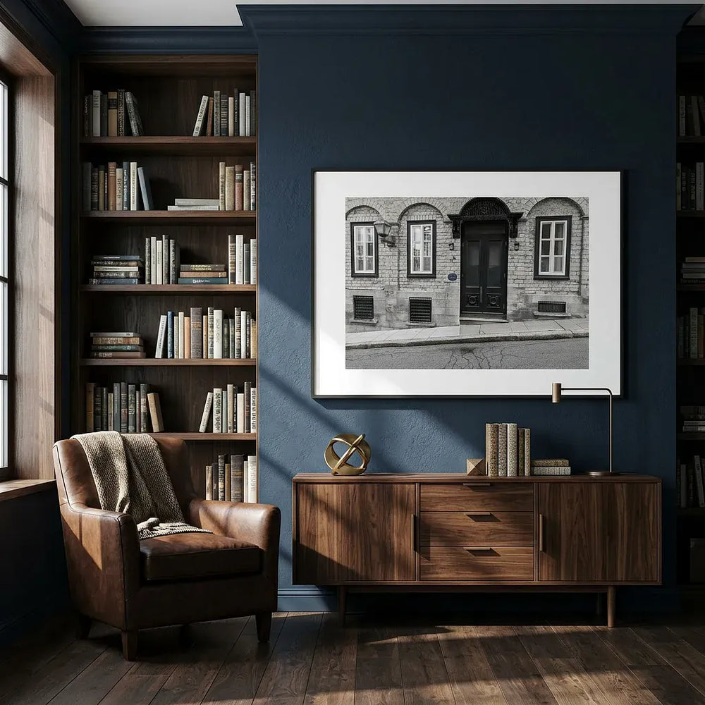 Nestled corner of a room with a bookshelf, armchair, and framed picture by Studio Shefford on a blue wall