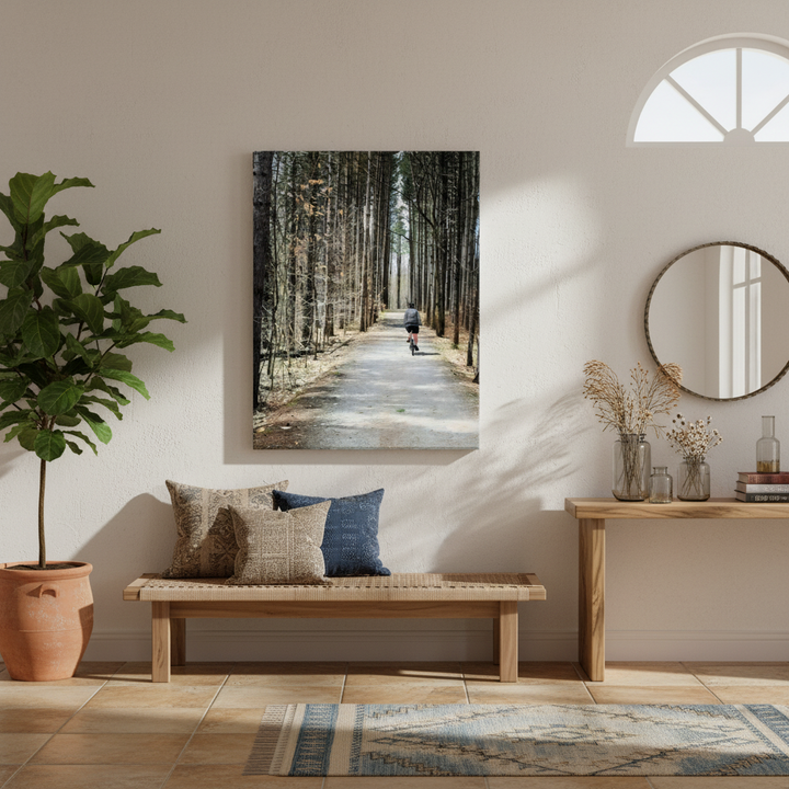 Home entryway with a wooden bench, decorative pillows, a plant, and wall art of a forest path - by Studio Shefford on Bromont Media