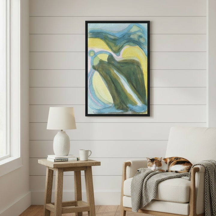 Living room with abstract art on the wall, wooden side table, and chair with a cat - Bromont Media