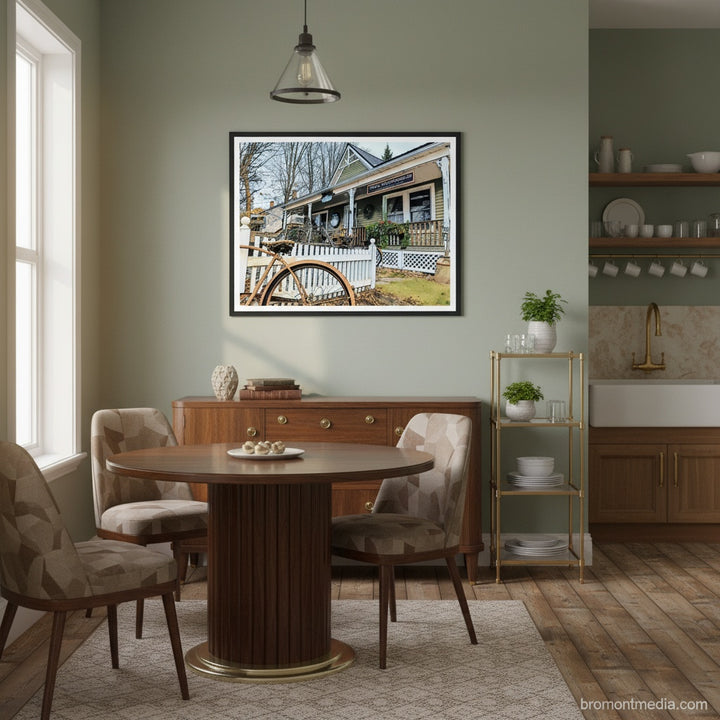 Dining room with a wooden table, chairs, and a framed vintage bakery picture on the wall - Studio Shefford