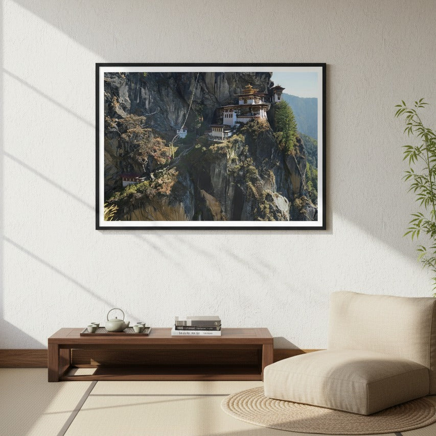 Framed landscape print of a mountainous scene with the Taktsang Monastery on a wall in a modern living room - Bromont Media