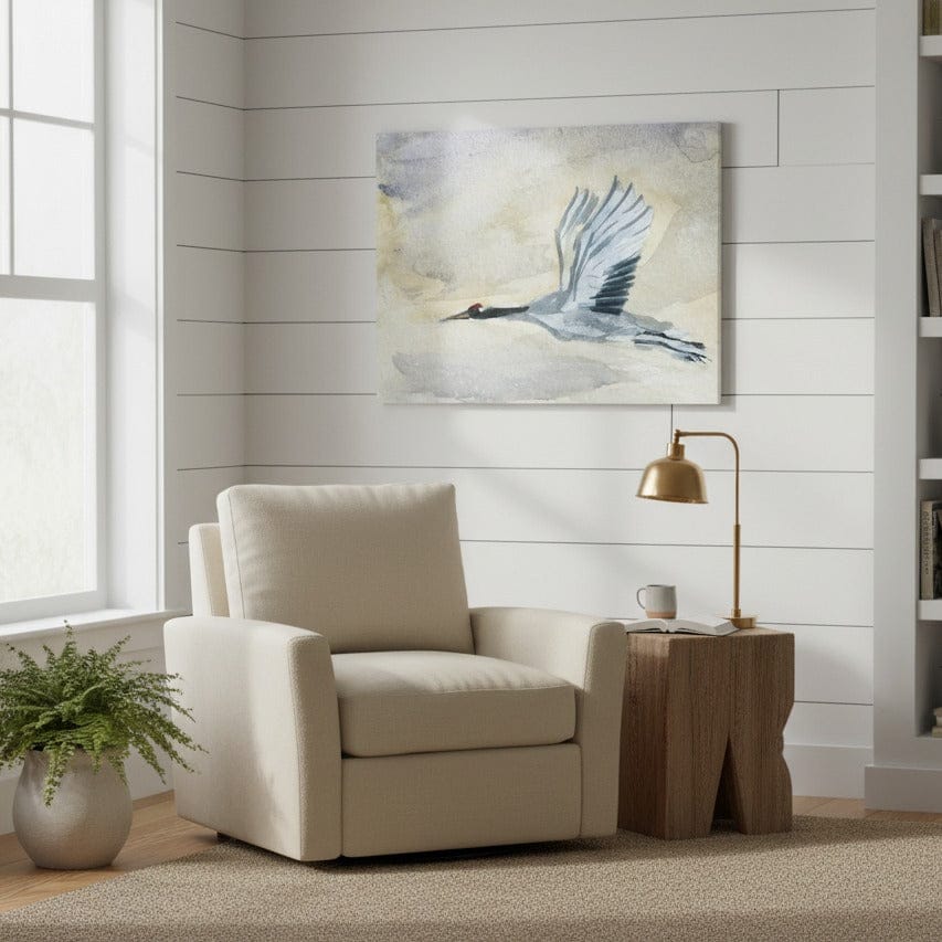 Beige armchair in a room with a painting of a Blue Huron, lamp, and plant - Bromont Media
