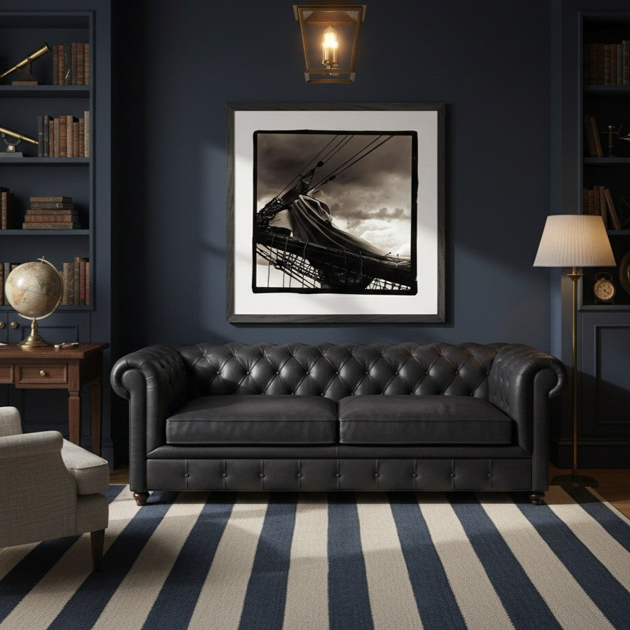 Living room with a black leather sofa, framed picture on the wall, and striped rug - Bromont Media