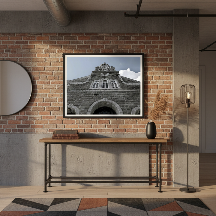 Framed Church facade art print on a brick wall above a wooden console table with decorative items - Studio Shefford
