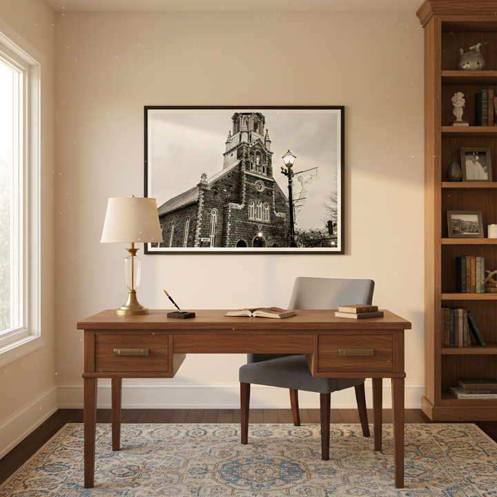 Wooden desk with chair, lamp, and framed church facade picture in a home office setting - Studio Shefford