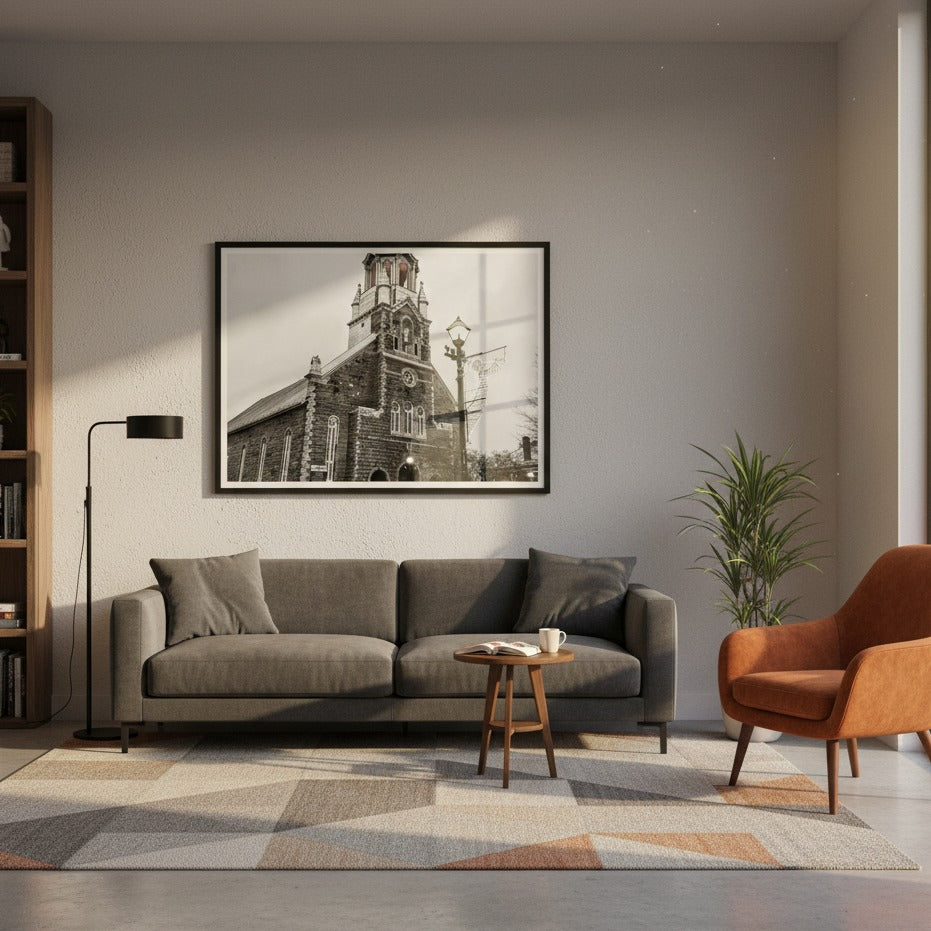Living room with a gray sofa, a brown armchair, and a framed church picture on the wall - Studio Shefford