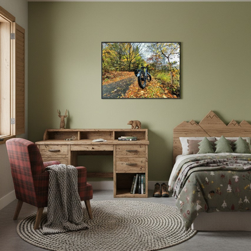 Bedroom with a wooden desk, a plaid chair, and wall art of a forest path with a fat bike - Studio Shefford