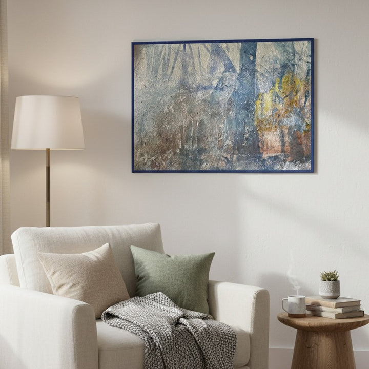 Living room with a white armchair, abstract painting, and lamp.