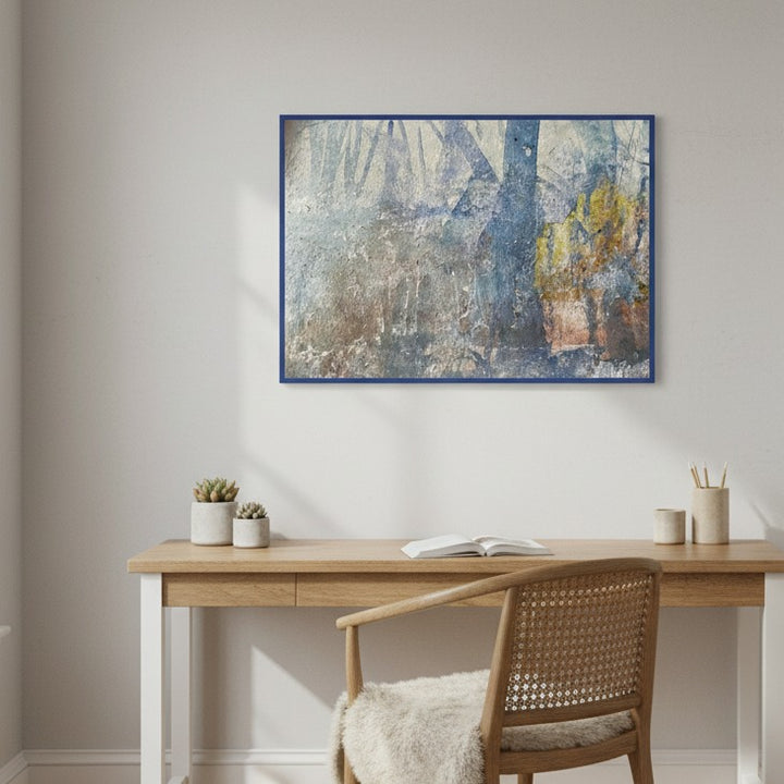 Abstract painting on a wall above a wooden desk with a chair.