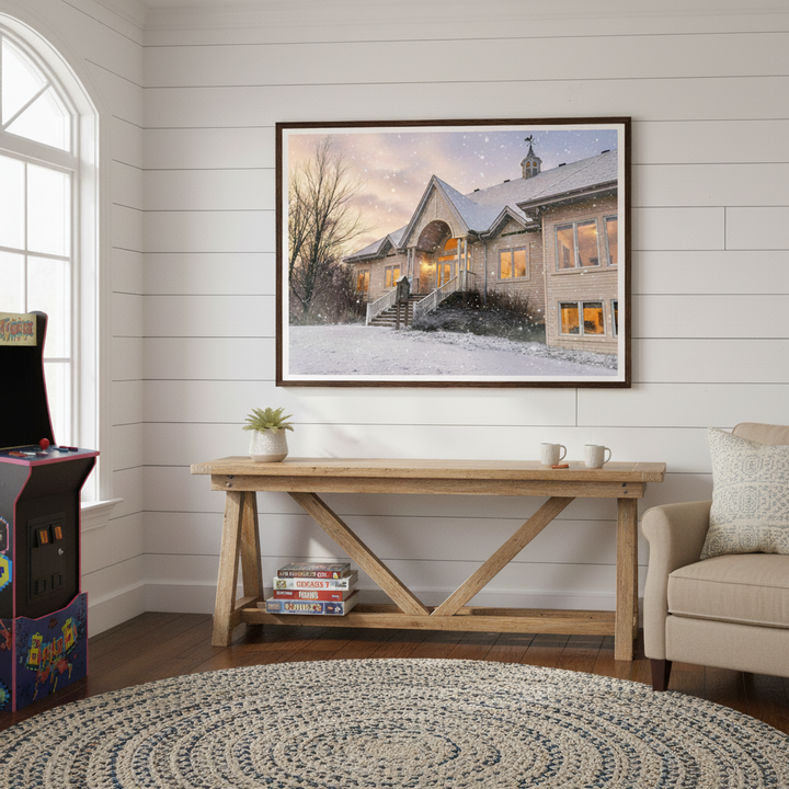 Living room with a framed picture of a golf club by Studio Shefford, wooden table, and arcade machine.