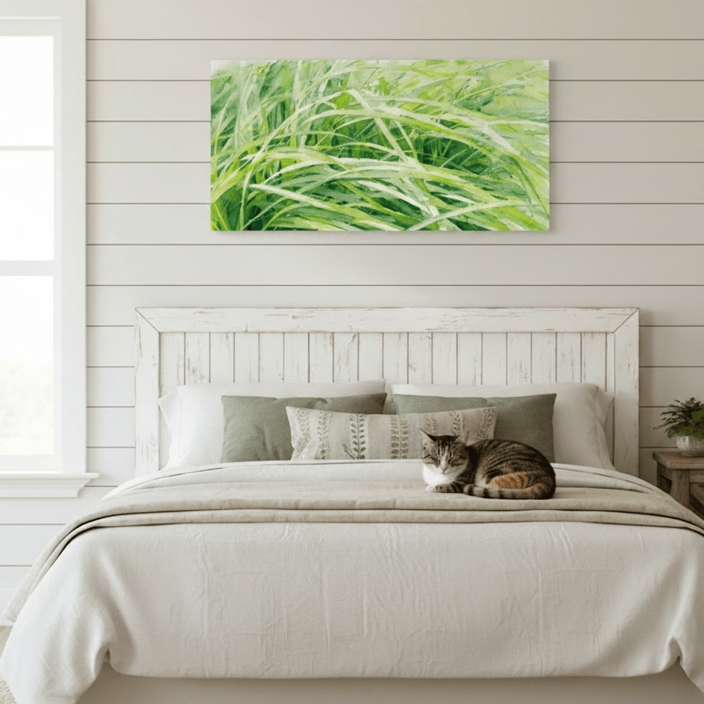 Cat lying on a bed with a green nature painting above it in a bedroom setting