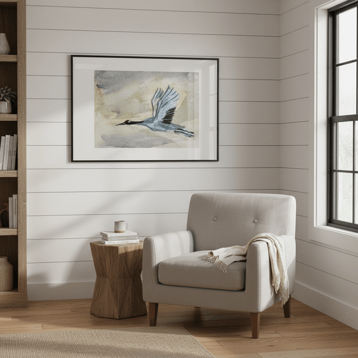 Cozy living room with a gray armchair, wooden side table, and framed artwork on the wall.