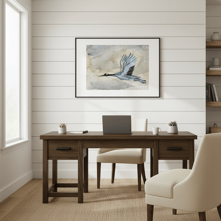 Home office with wooden desk, chair, and framed Blue Huron artwork on a white wall - Bromont Media