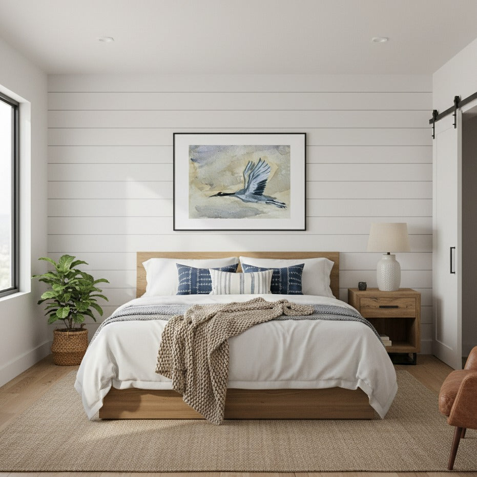 Modern bedroom with wooden bed, white bedding, decorative pillows, and a framed Blue Heron artwork on the wall by Andrew Semple