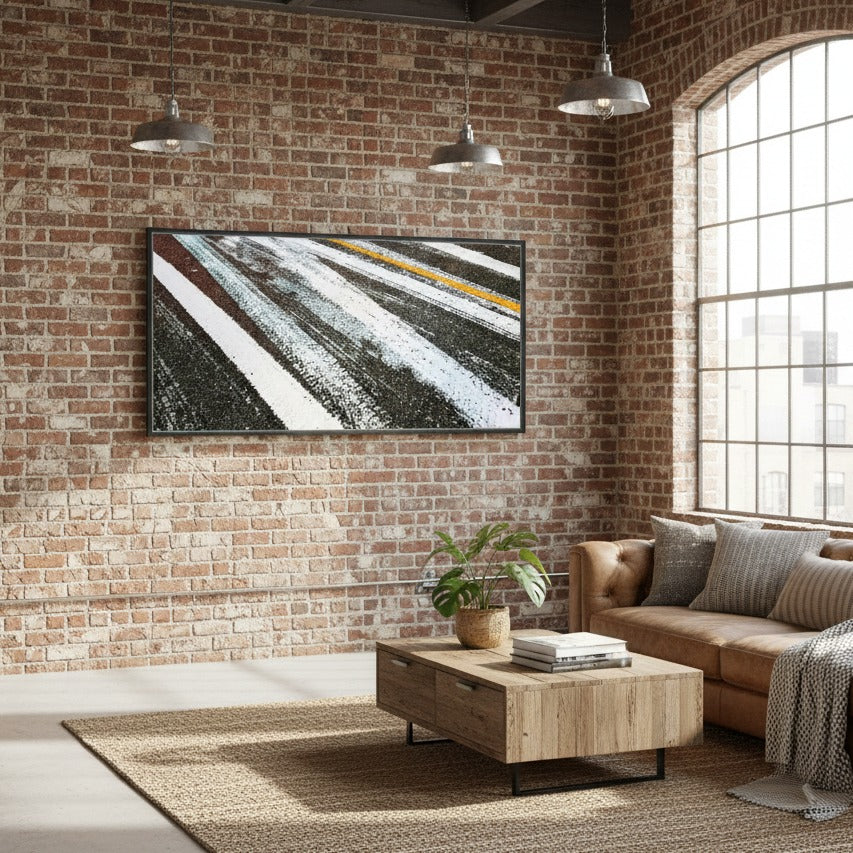 Modern living room with brick wall, TV, sofa, and coffee table - Bromont Media