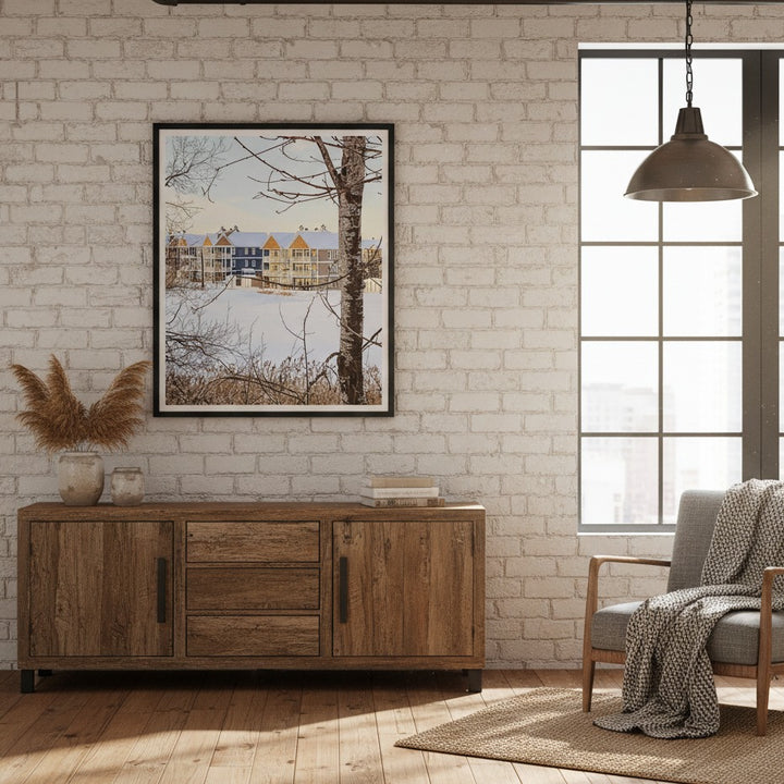 Living room with wooden sideboard, gray sofa, and framed picture by Studio Shefford on brick wall.