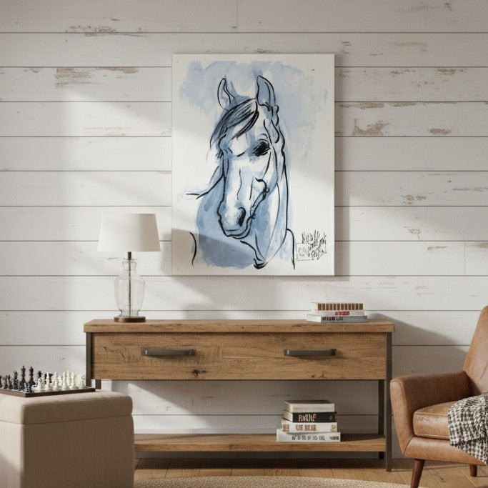 Horse painting on a wall above a wooden console table in a room with a lamp and books - Bromont Media