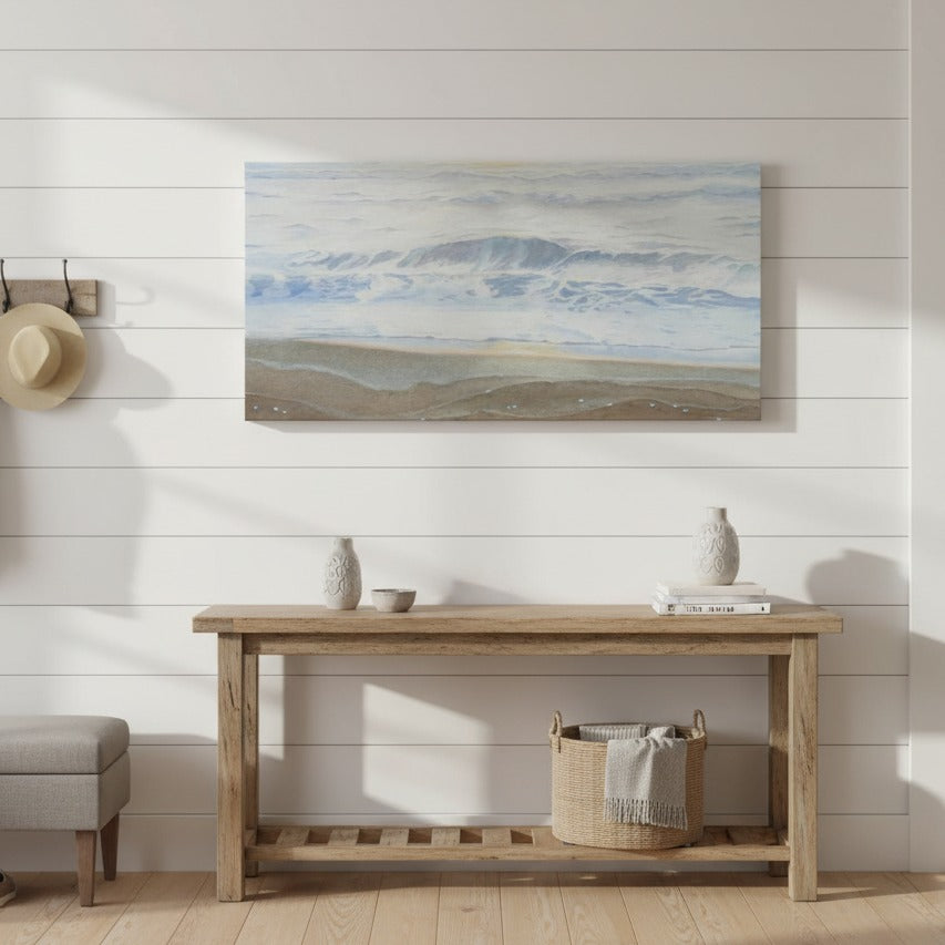 Nautical-themed wall art above a wooden console table in a room with a white wall and wooden floor - Bromont Media